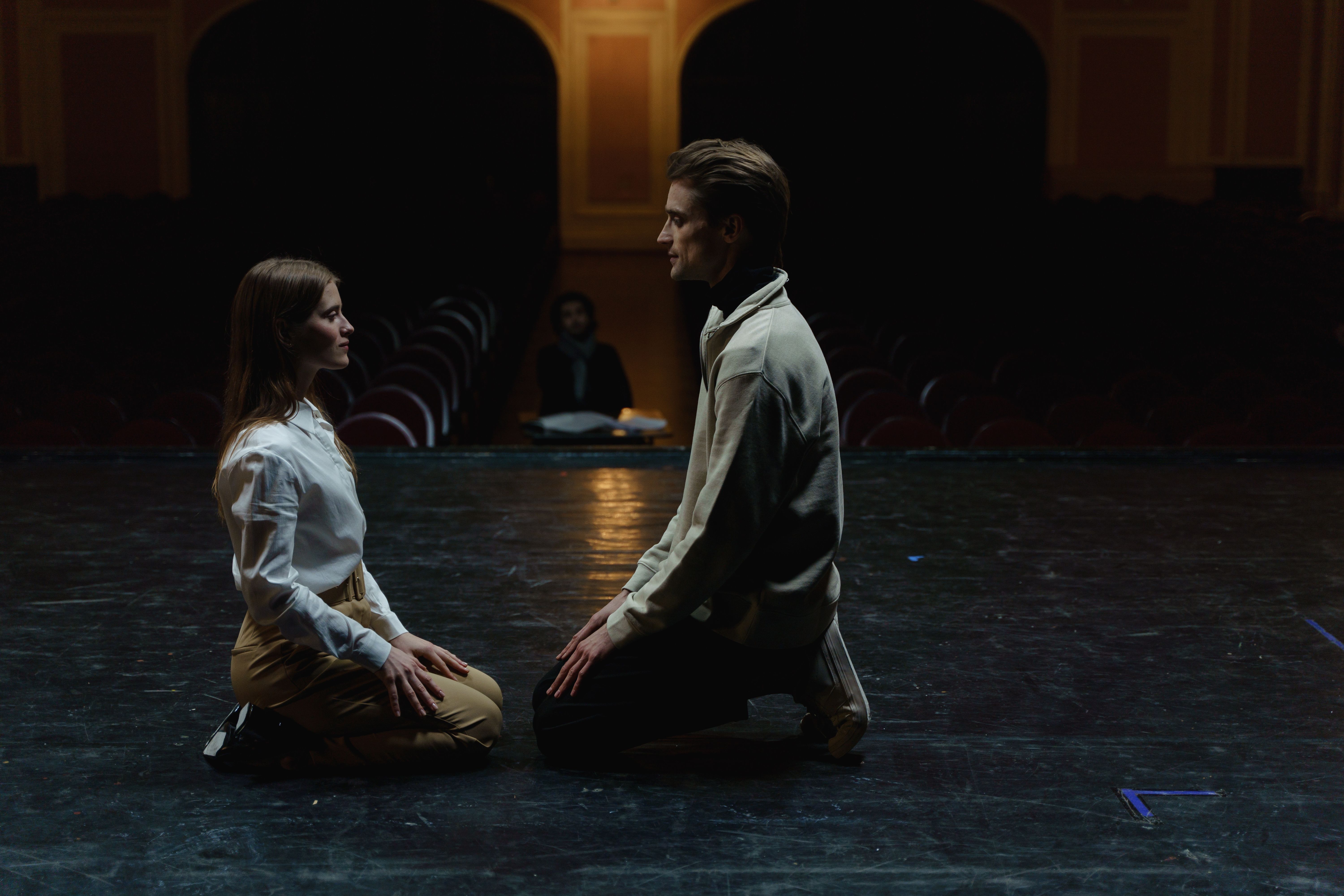 Deux comédiens face à face sur un plateau de théâtre